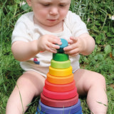 Baby playing with the Grimms large conical tower in a Grimm’s World of Numbers palette