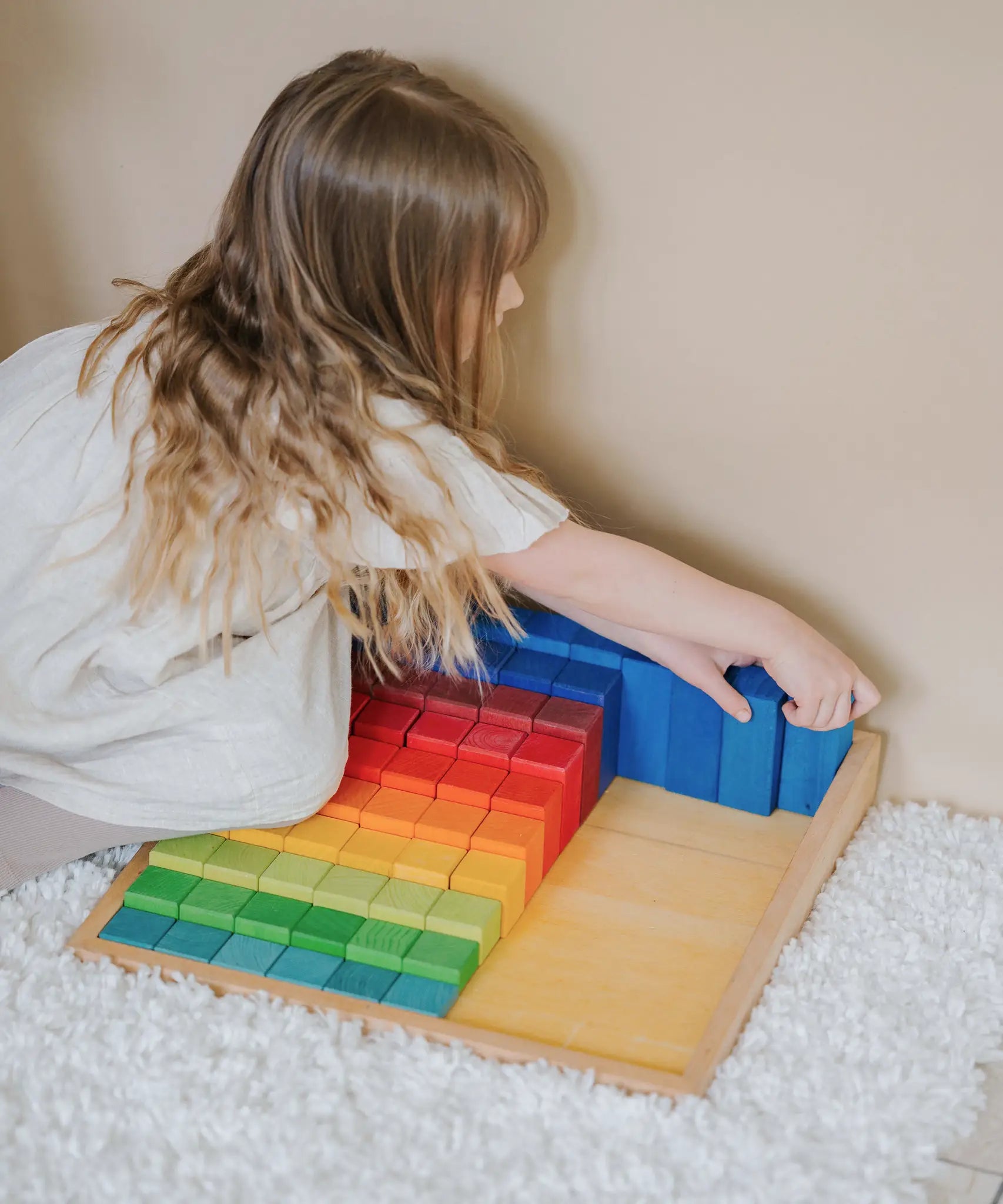 Child sorting the blocks from the Grimms large stepped wooden counting set