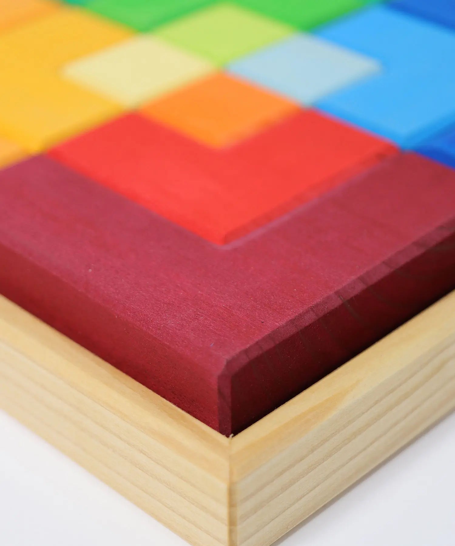 Close up of the Grimm's large creative puzzle square wooden toy in a wooden storage display tray. 