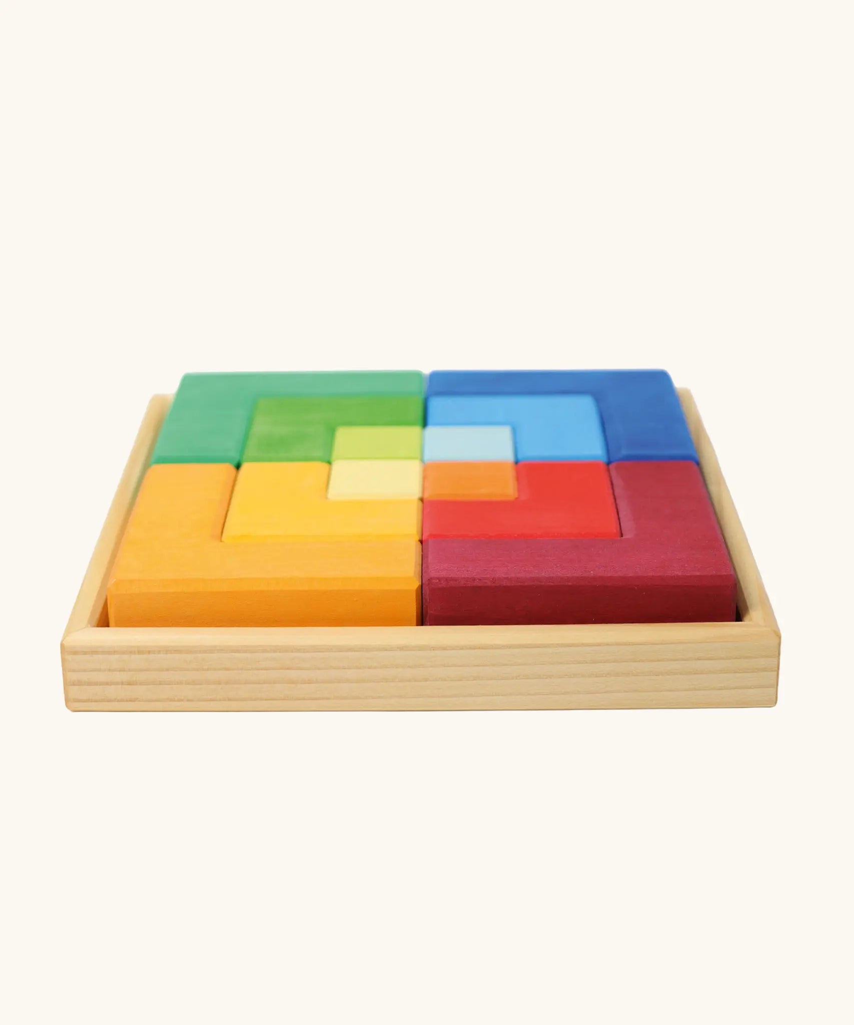 Side view of the Grimm's large creative puzzle square wooden toy in a wooden storage display tray. 