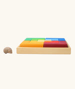 Side view of the Grimm's large creative puzzle square wooden toy in a wooden storage display tray. 