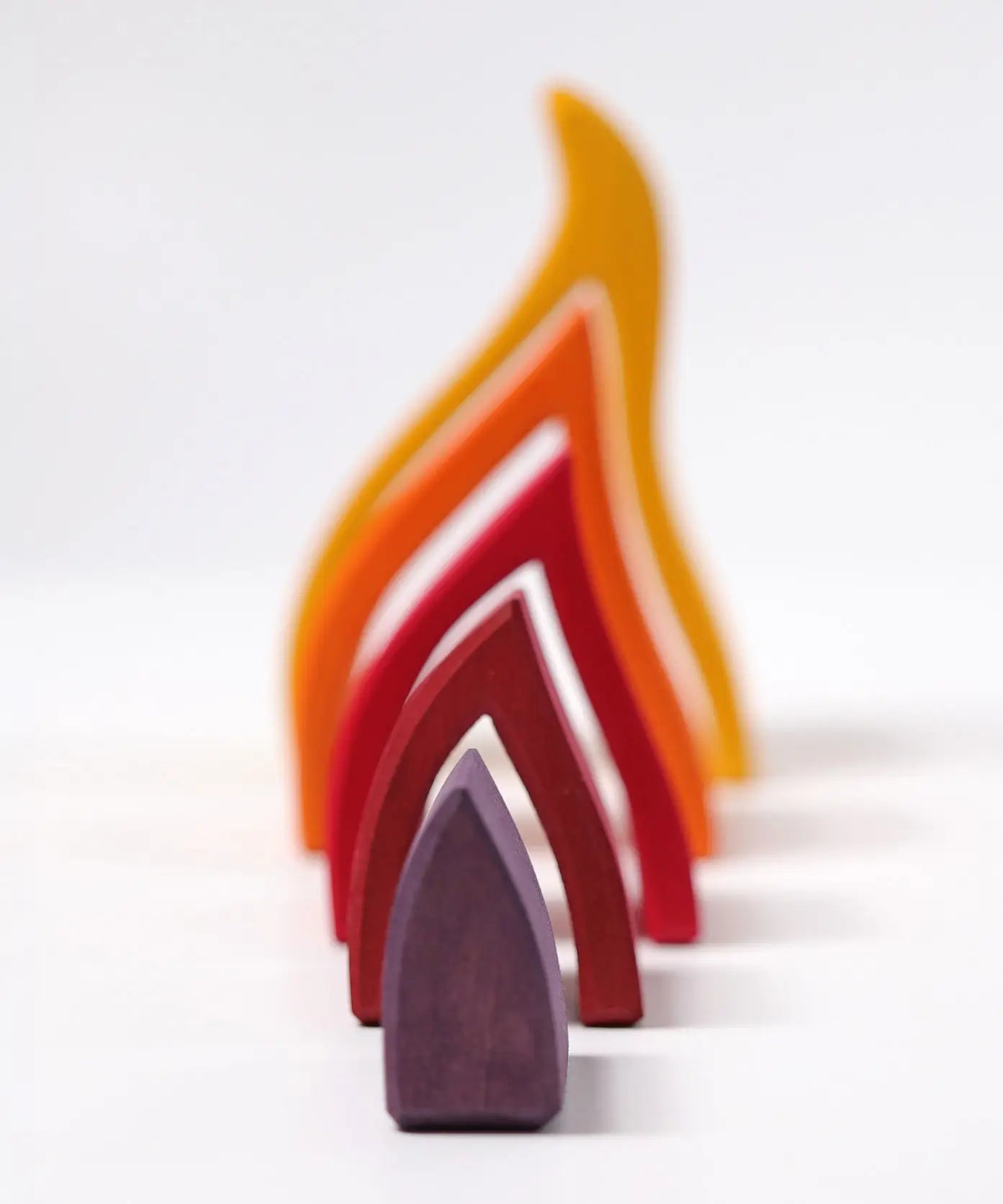 Grimms handcrafted wooden fire set showing each flame piece lined up from small to large
