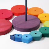 Loose Grimms geometric wooden blocks in a shape of a swirl around the purple base