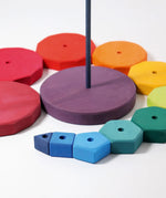 Loose Grimms geometric wooden blocks in a shape of a swirl around the purple base