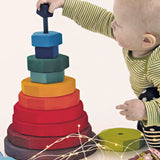 Child threading the blocks from the Grimms large geometric tower stacker toy