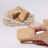 Adult's hand holding a block from the Grimm's large wooden natural building blocks set.