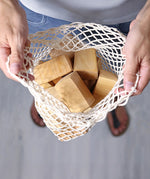 Grimm's large wooden natural building blocks set in their string storage bag .