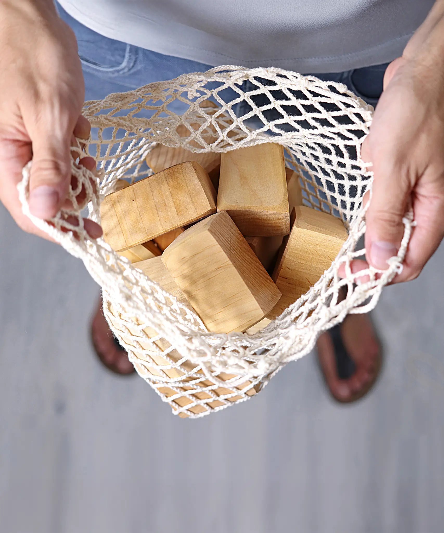 Grimm's large wooden natural building blocks set in their string storage bag .