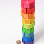 The triangular shaped wooden blocks from the Grimm's Large Octagon Puzzle Set stacked up to create a tower.