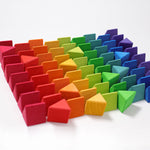 The triangluar shaped blocks from the Grimm's Octagon Puzzles paid out and lined up on a flat white surface. 
