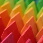 A close up of the triangle shaped wooden blocks from the Grimm's Large Octagon Puzzle. 