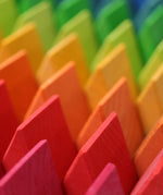 A close up of the triangle shaped wooden blocks from the Grimm's Large Octagon Puzzle. 