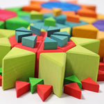 A close up, side view of the triangular shaped blocks from the Grimm's Octagon Puzzles used to created flower shapes withe the large set used for the flowers and the smaller sets used for the stems and details. 