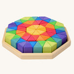 Grimm's Large Octagon Wooden Puzzle set containing rainbow coloured triangular shaped blocks in a wooden storage tray. 