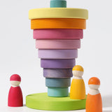 Grimms large conical tower in pastel colours showing a stack inverted on the base with peg dolls standing near 