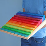 Adult holding a Grimms large stepped wooden counting blocks in Grimm’s World of Numbers palette 