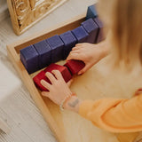 Adult sorting individual blocks from the Grimms large stepped wooden counting blocks