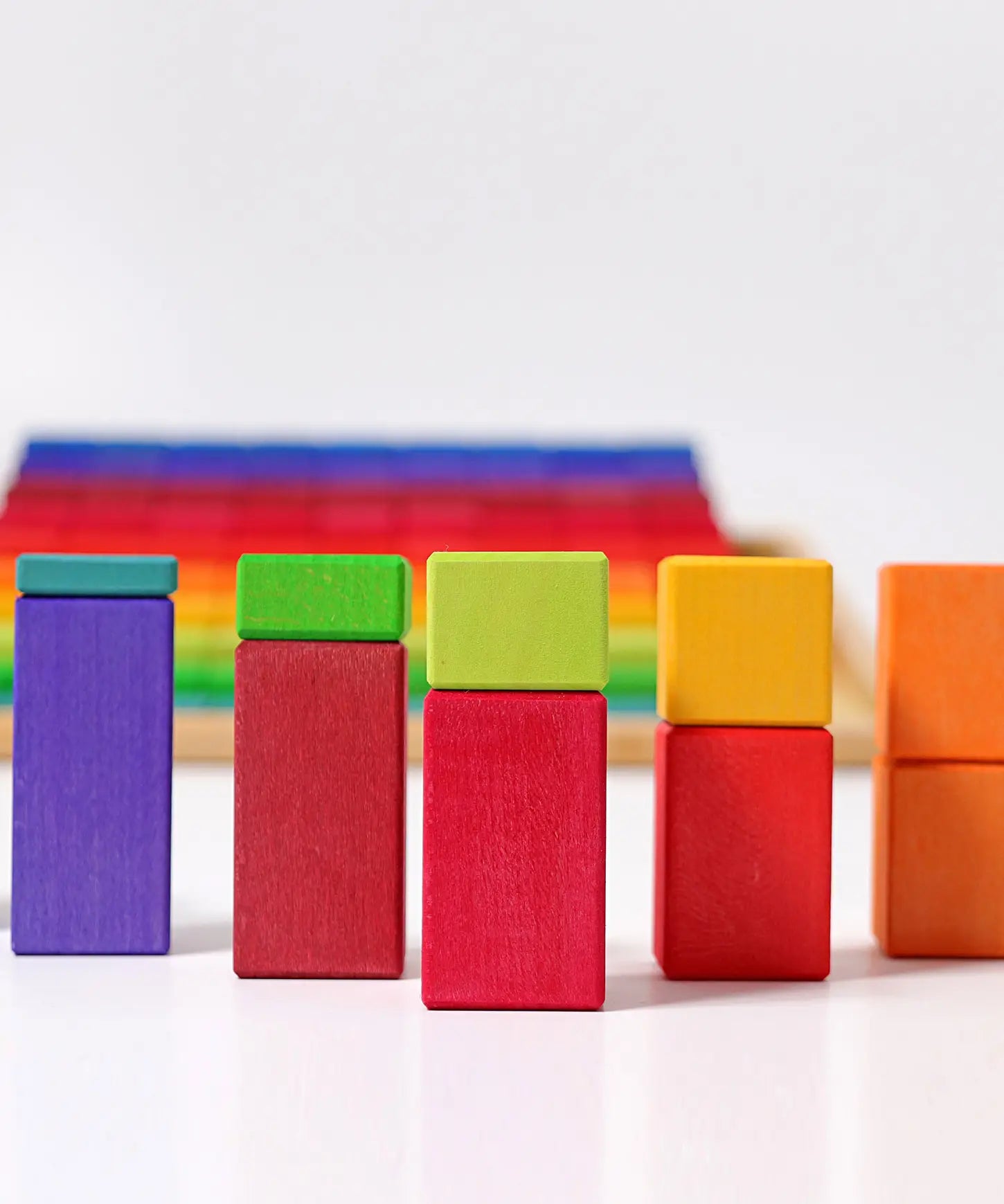 Grimms large stepped wooden counting blocks in Grimm’s World of Numbers palette made for counting and learning. Stacked into a visual math fraction