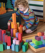Grimm's large stepped pyramid coloured wooden blocks being played with by a child in the Babipur playroom.