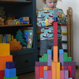 Grimm's large stepped pyramid coloured wooden blocks being stacked by a child in the Babipur playroom.