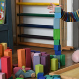 Grimm's large stepped pyramid coloured wooden blocks being stacked by a child in the Babipur playroom.