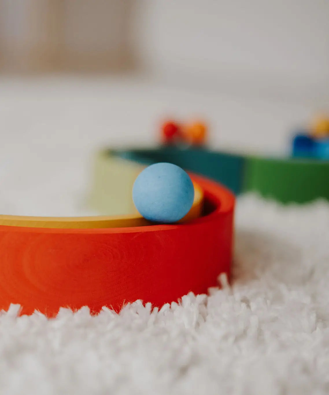 Close up of a Grimms small light blue ball on a ball run