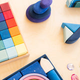 Grimms limited edition dream pebbles on a table next to rainbow cubes and a polar light set.