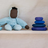Grimm's dream limited edition handcrafted wooden pebbles displayed on a shelf next to a waldorf doll