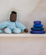 Grimm's dream limited edition handcrafted wooden pebbles displayed on a shelf next to a waldorf doll