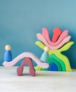 Pieces from the Grimms wooden little flower set made into a see saw with peg dolls sitting on top