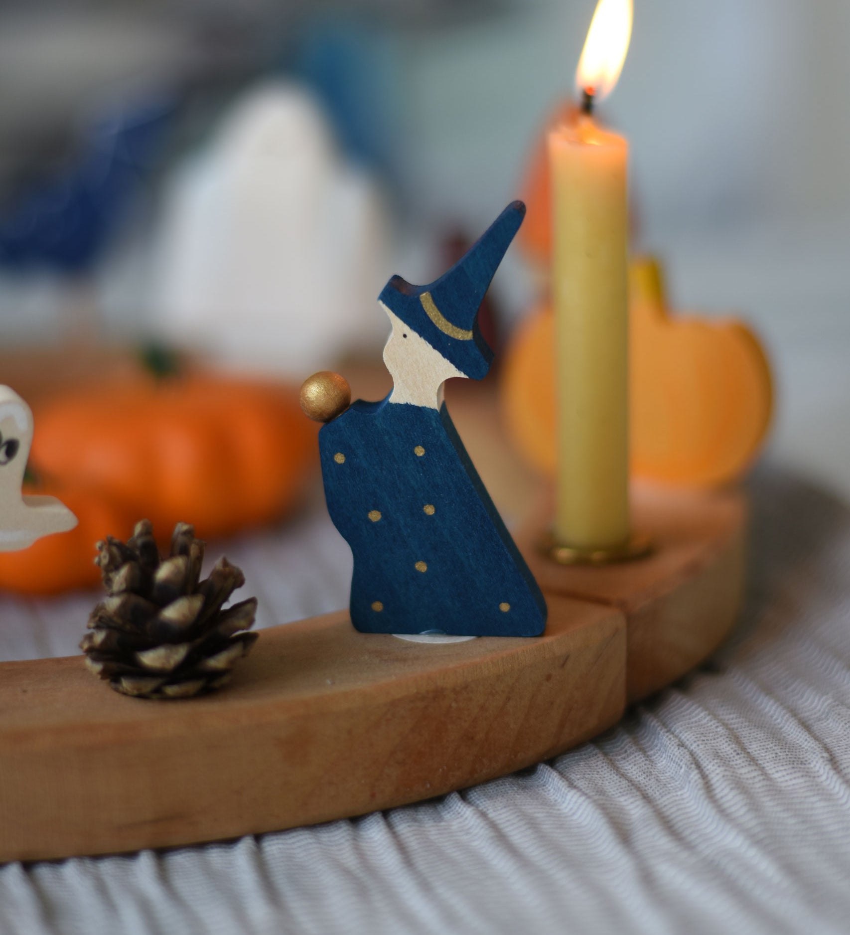 A Grimm's Magician Decorative Figure placed on a natural Grimm's celebration ring. 