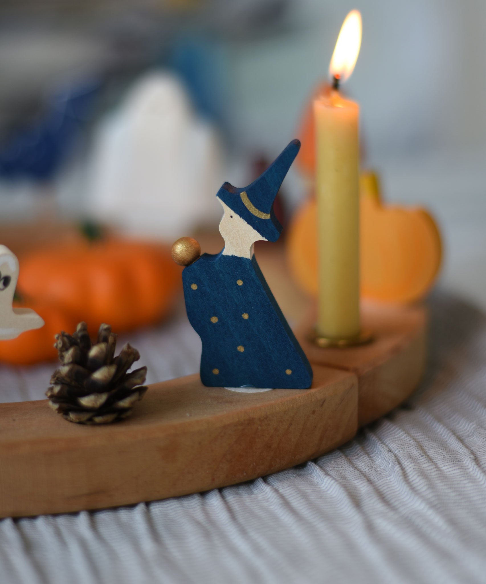 A Grimm's Magician Decorative Figure placed on a natural Grimm's celebration ring. 