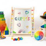 Pieces from the Grimms magnet alphabet puzzle on a Triclimb Biri board next to other popular rainbow block and buildings sets