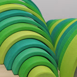 A close up of the Grimms meadow large green wooden rainbow set available at Babipur showing the grain detail