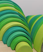 A close up of the Grimms meadow large green wooden rainbow set available at Babipur showing the grain detail