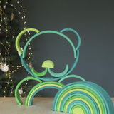 A stack shaped like a teddy bear's face made from the pieces of the Grimms meadow large green wooden rainbow set available at Babipur.