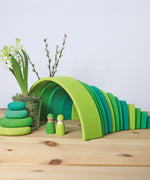 A cute little display using the Grimms meadow large green wooden rainbow, green pebbles and 2 green friends, all available at Babipur.