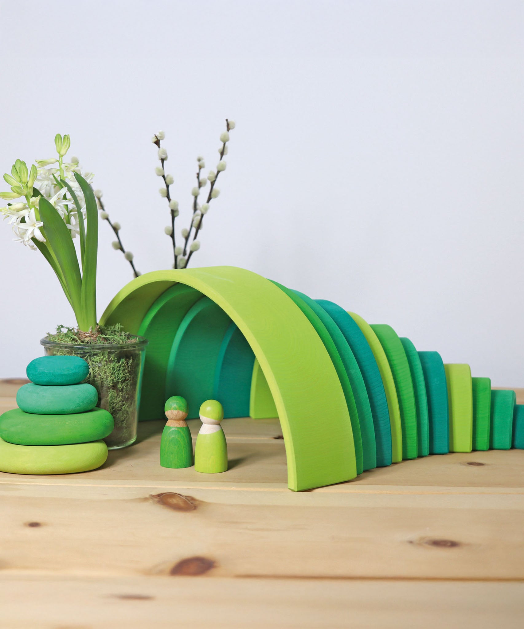 A cute little display using the Grimms meadow large green wooden rainbow, green pebbles and 2 green friends, all available at Babipur.