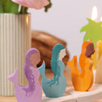 A close up of the purple, blue and orange mermaid wooden decorative figures slotted in the celebration ring