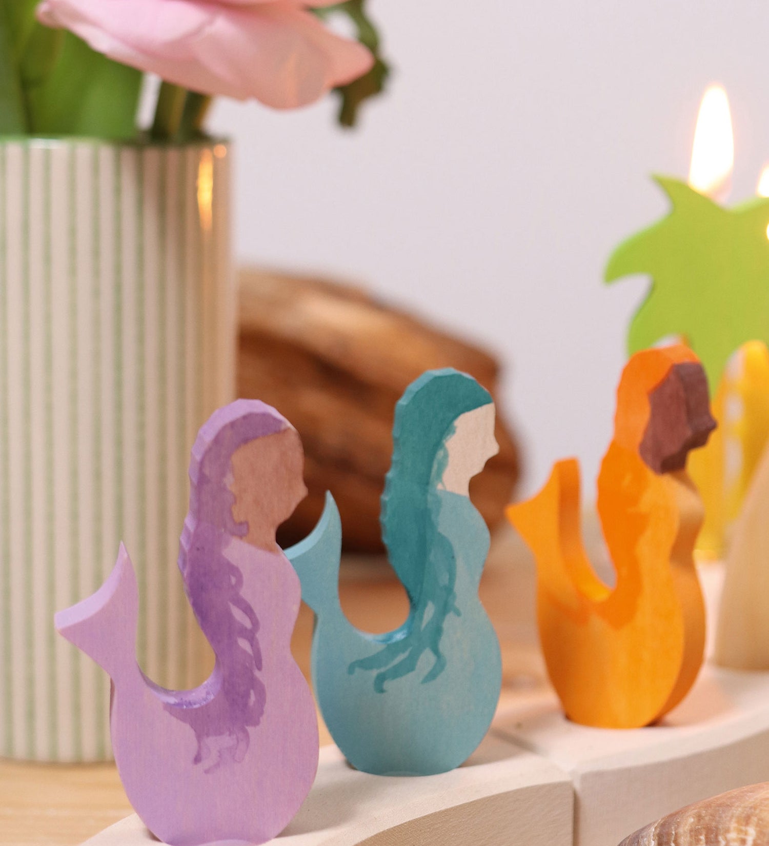 A close up of the purple, blue and orange mermaid wooden decorative figures slotted in the celebration ring