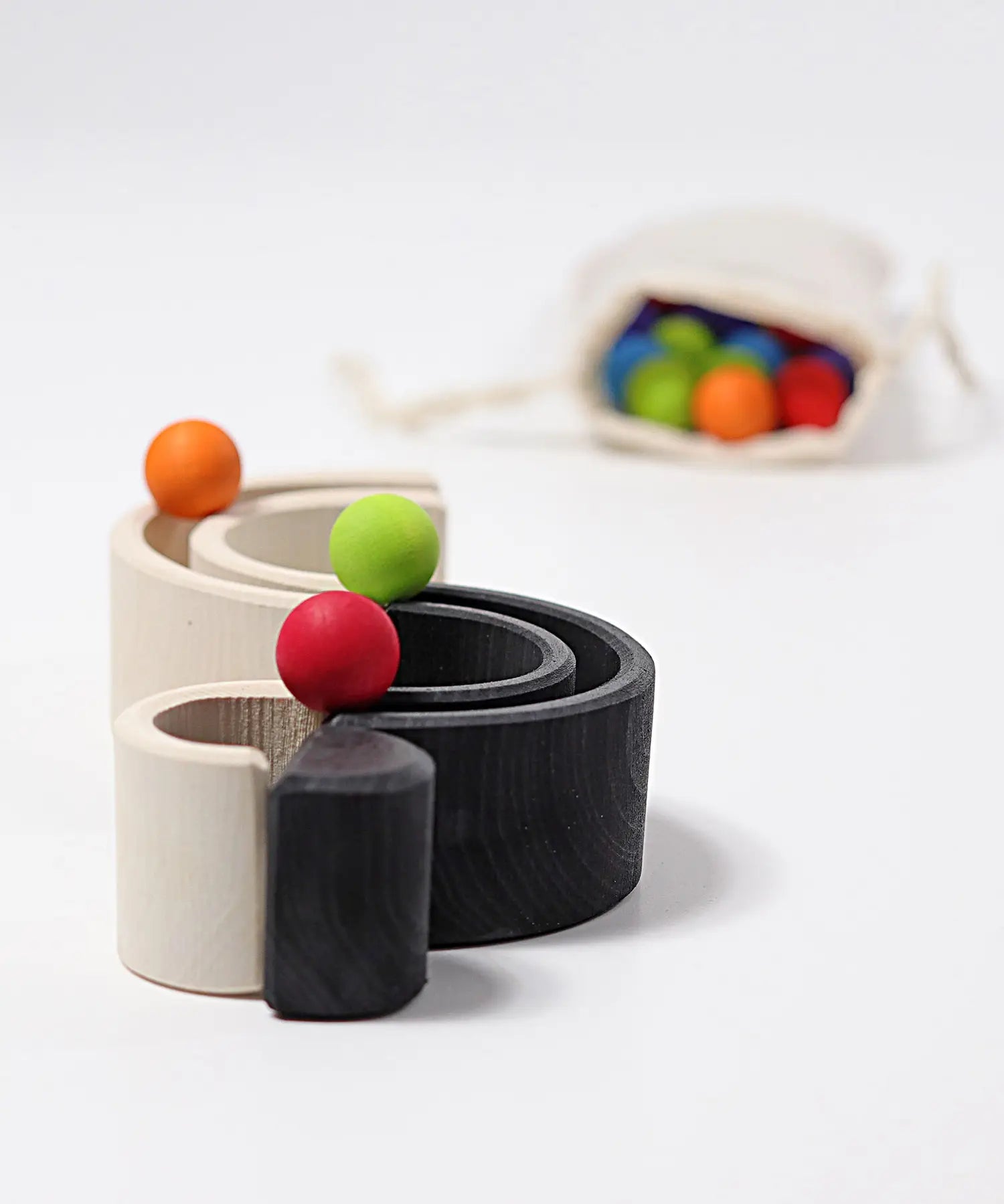 Grimm's mini monochrome wooden rainbow used as a mini ball run. 
