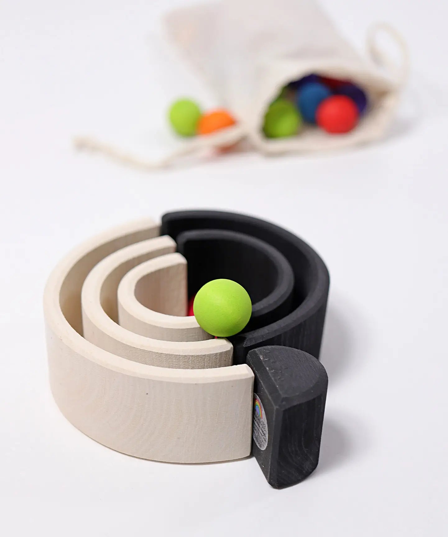 Grimm's mini monochrome wooden rainbow used as a mini ball run. 