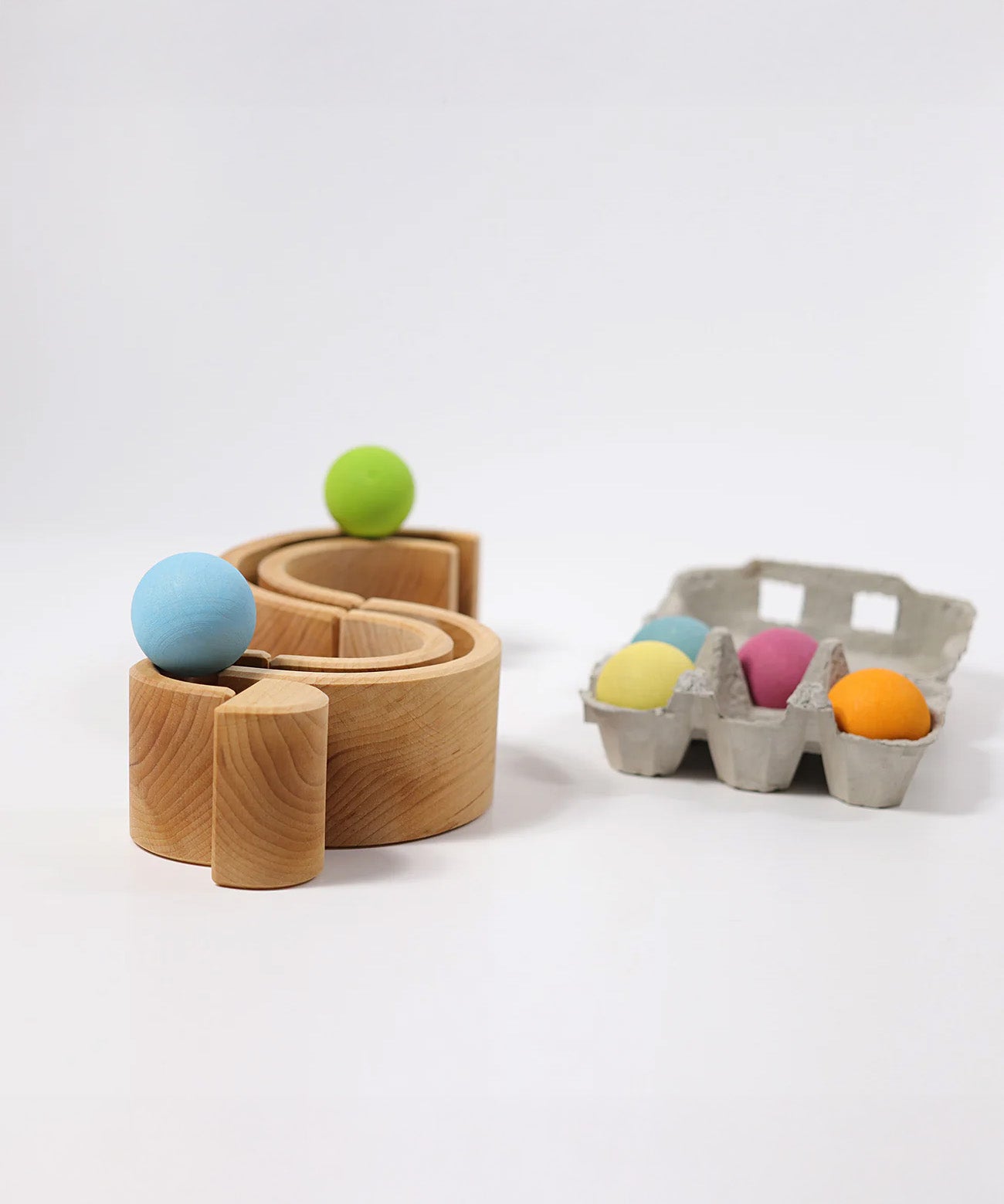 A mini ball run made from piece Grimms rainbow stacking toy available at Babipur with the pastel balls running along the top