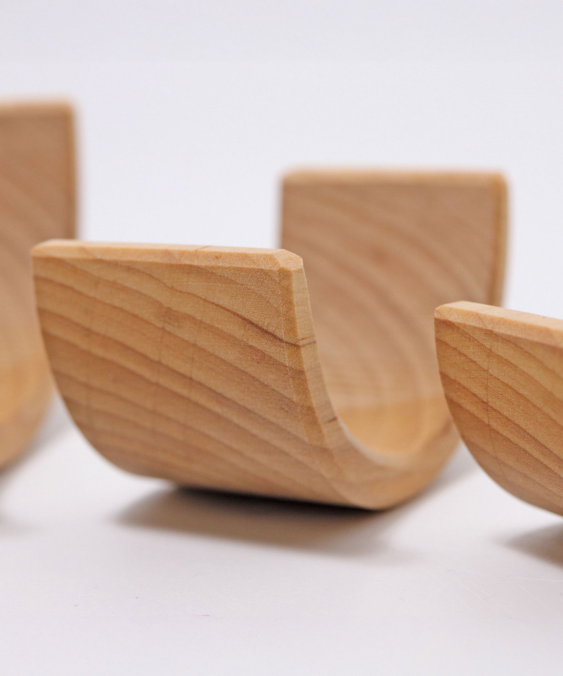 A close up of the Grimms natural wooden rainbow stacking toy available at Babipur showing the grain detail on the arch