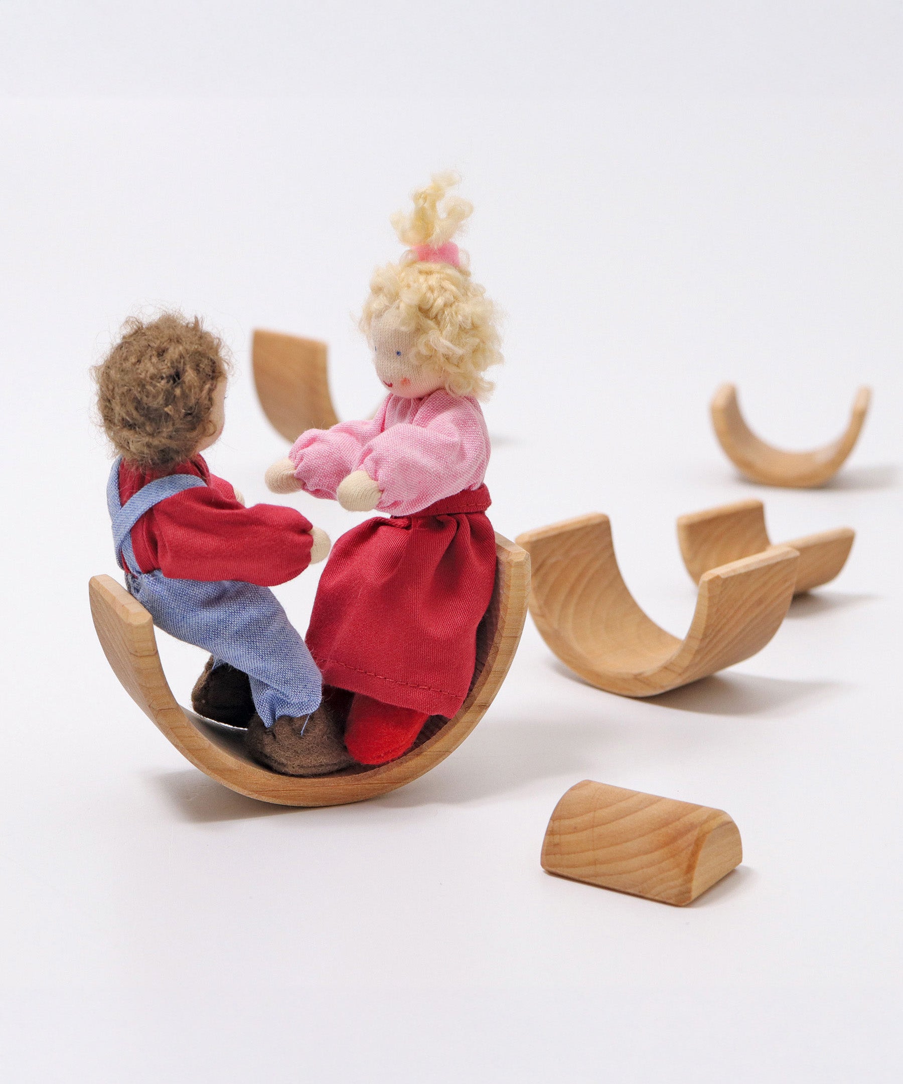 2 Grimms dolls sitting inside one of the arches from the Grimms natural wooden rainbow stacking toy available at Babipur. 