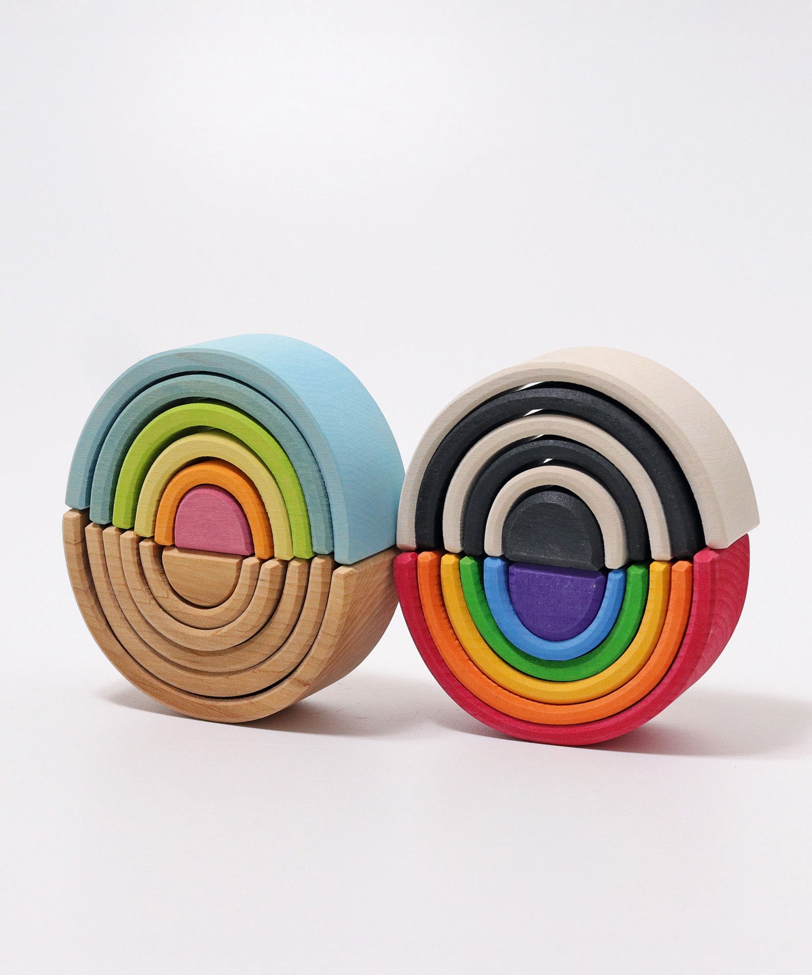 A Grimms mini pastel, natural, monochrome and bright rainbow stacking toy on top of each other. These sets are available at Babipur