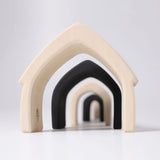 Loose Grimms handcrafted wooden monochrome house pieces lined up from large to small. 