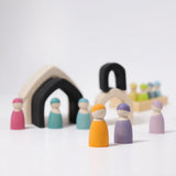 Loose Grimms monochrome house pieces next to pastel friends peg dolls in a play setup