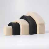 Individual wooden Grimms monochrome house pieces lined up from large to small. 