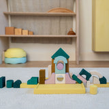A simple construction made from Grimms movement building set on a fluffy rug in a playroom